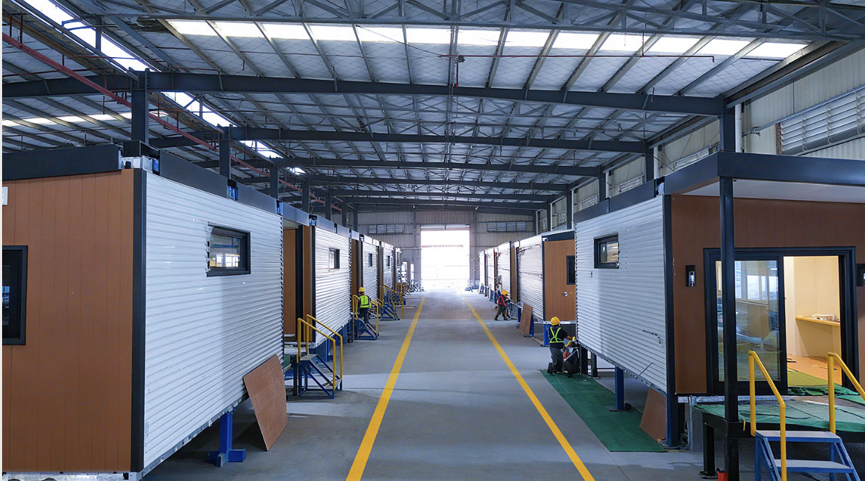 Modular factory aisle — completed module shells lined up for fit-out